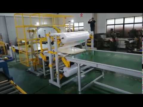 Bubble film wrapping machine with orbital wrapepr for door packaging.